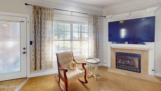 a living room with furniture a flat screen tv and a fireplace