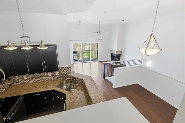 a kitchen with granite countertop a sink dishwasher a stove and a refrigerator