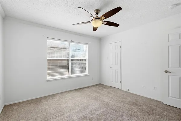 an empty room with a window and a fan