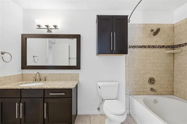 a bathroom with a granite countertop sink a toilet and mirror