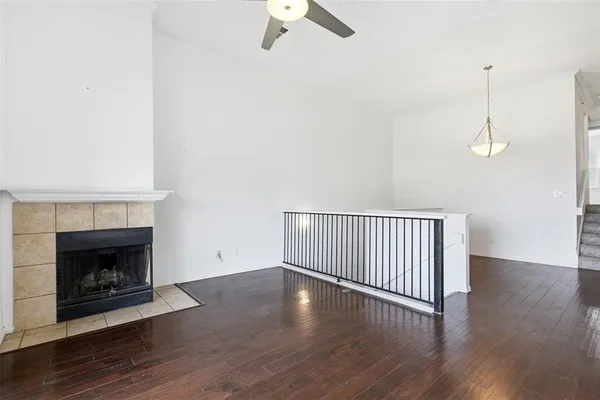 a view of empty room with wooden floor fireplace and a window