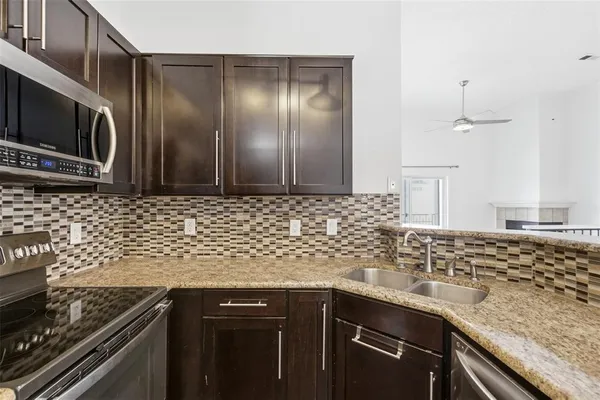 a kitchen with stainless steel appliances granite countertop a sink stove and microwave