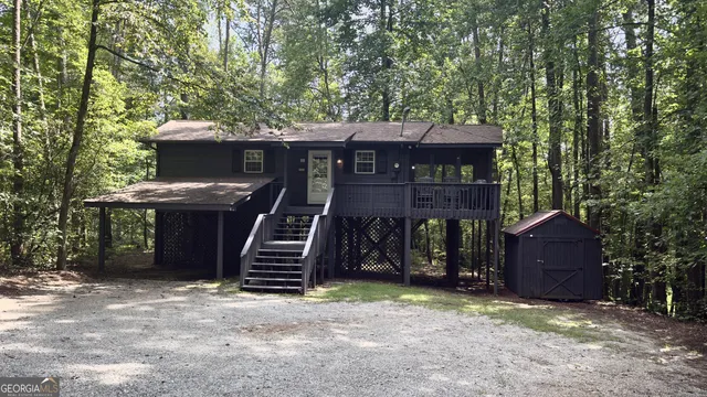 a view of a wooden house with a large tree