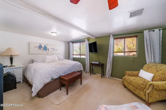 a spacious bedroom with a bed couch and window