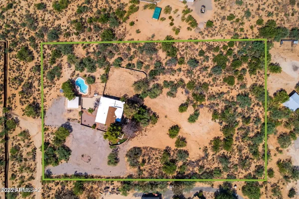 an aerial view of a residential houses with outdoor space and parking
