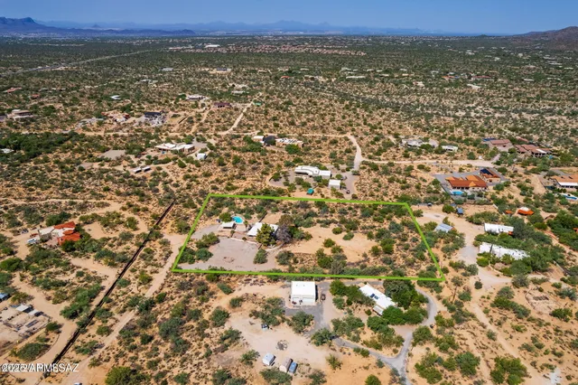 an aerial view of residential houses with outdoor space and trees