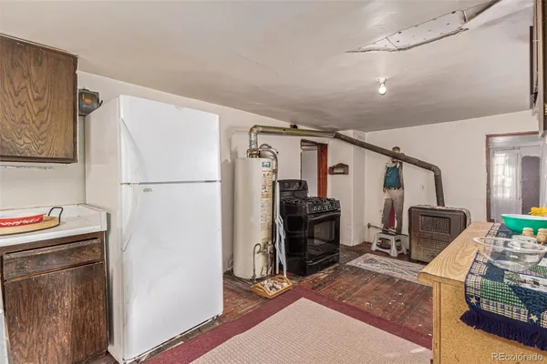 a walk in closet with wooden floor and furniture