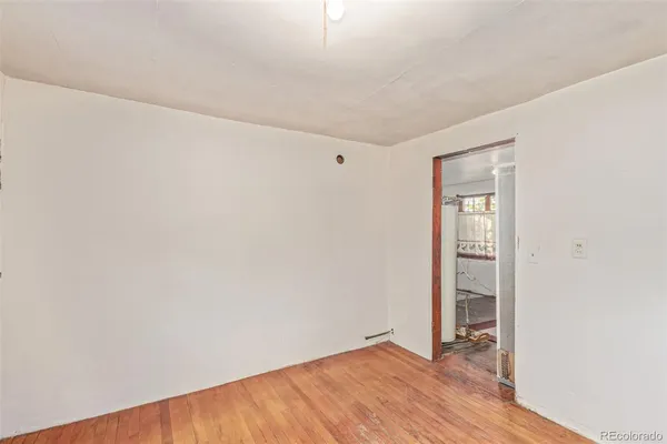 an empty room with wooden floor and closet