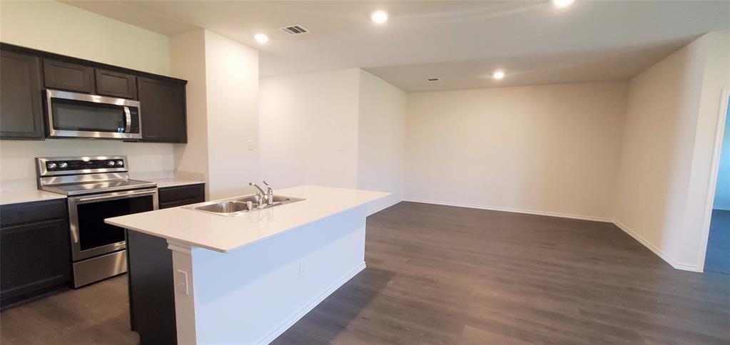 2125 Basil Avenue Anna, TX 75409 - Photo 3 of 12 a kitchen with a sink and a stove top oven with wooden floor