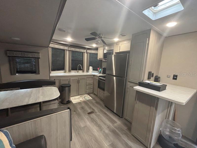 14403 Northeast 252nd Ct Road, Unit 128 Fort McCoy, FL 32134 - Photo 11 of 23 a kitchen with a sink a refrigerator and chairs