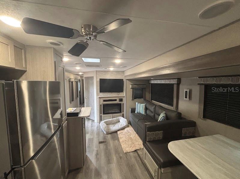 14403 Northeast 252nd Ct Road, Unit 128 Fort McCoy, FL 32134 - Photo 12 of 23 a kitchen with stainless steel appliances kitchen island granite countertop a table chairs and a refrigerator