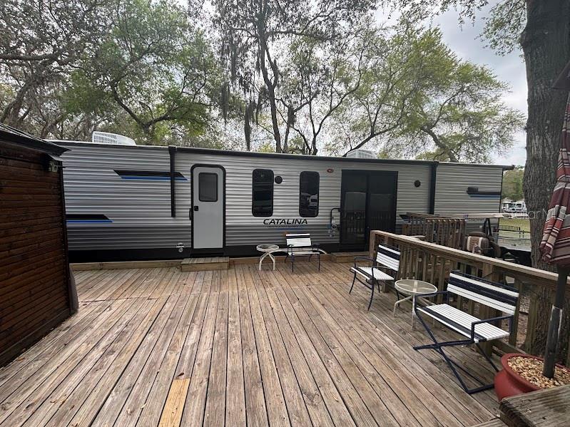 14403 Northeast 252nd Ct Road, Unit 128 Fort McCoy, FL 32134 - Photo 7 of 23 a view of house with deck outdoor seating and yard