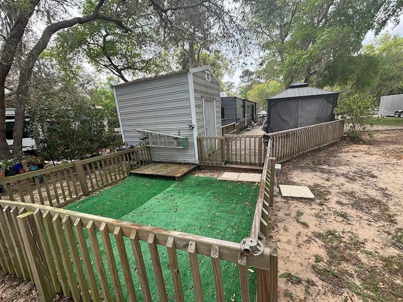 14403 Northeast 252nd Ct Road, Unit 128 Fort McCoy, FL 32134 - Photo 9 of 23 a view of a backyard with wooden fence and large trees