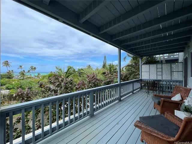 a view of a balcony with wooden floor & fence