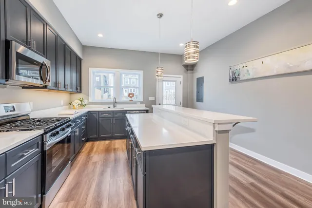 a kitchen with stainless steel appliances granite countertop a sink stove and refrigerator