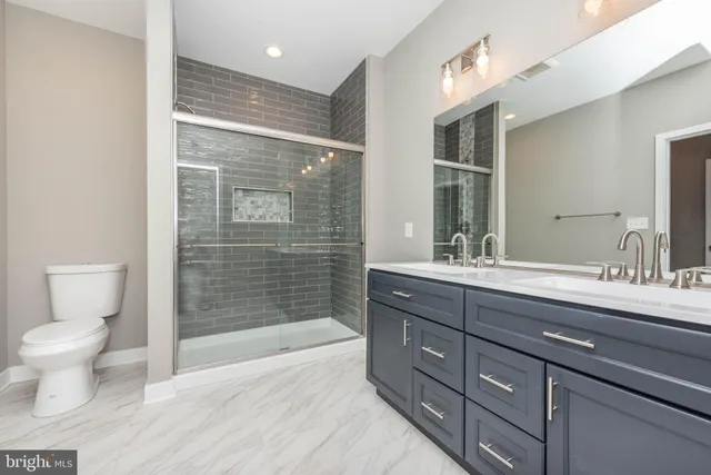 a bathroom with a toilet a sink and glass door