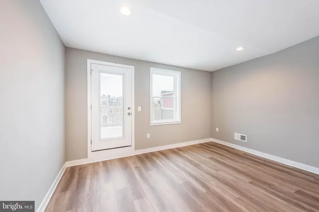 wooden floor in an empty room with a window