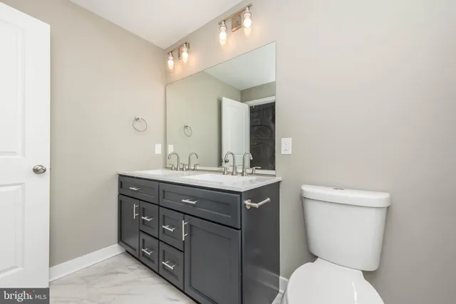 a bathroom with a toilet a sink and mirror