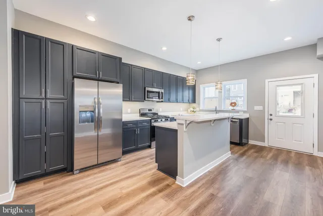 a kitchen with a refrigerator sink and cabinets