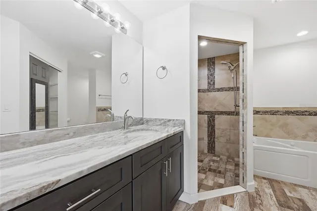 a bathroom with a granite countertop sink a toilet and a bathtub