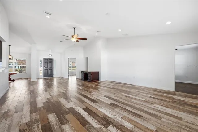 a view of a room with wooden floor and a ceiling fan
