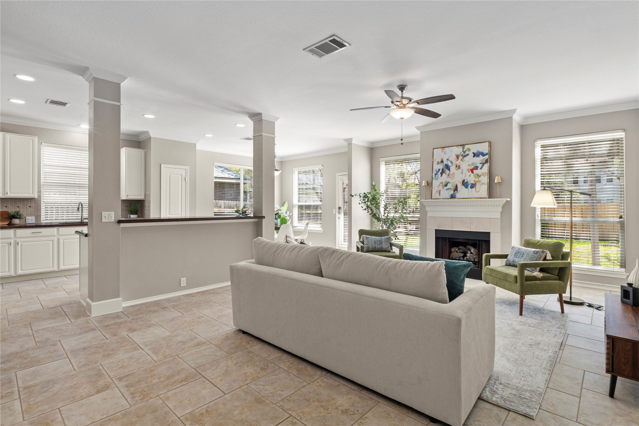 2210 Kerr Trail Cedar Park, TX 78613 - Photo 1 of 1 Step into a light-filled open concept living space. The spacious living room features neutral tones, crown molding, and a cozy fireplace, all seamlessly connected to the kitchen.