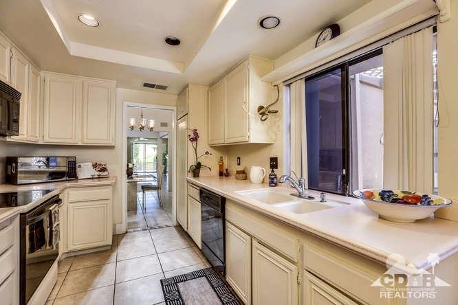 72399 Ridgecrest Lane Palm Desert, CA 92260 - Photo 16 of 34 a kitchen with a sink stove and cabinets