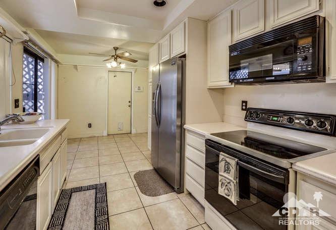 72399 Ridgecrest Lane Palm Desert, CA 92260 - Photo 18 of 34 a kitchen with granite countertop a stove and a microwave