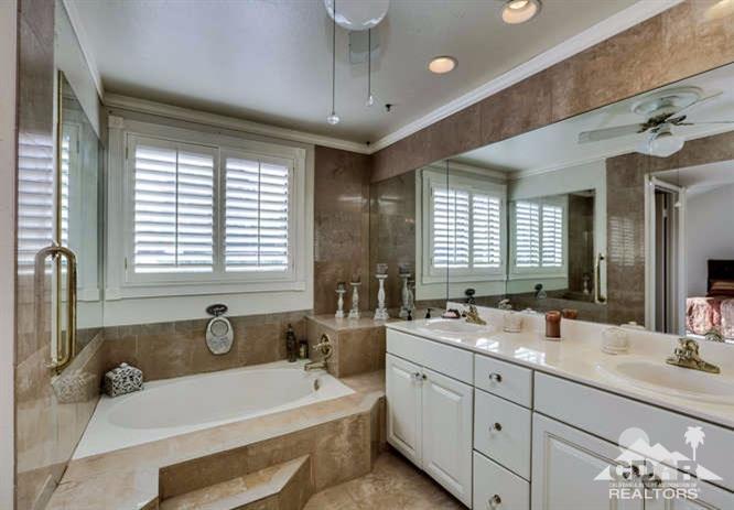 72399 Ridgecrest Lane Palm Desert, CA 92260 - Photo 25 of 34 a bathroom with double vanity sinks a large mirror and a bathtub
