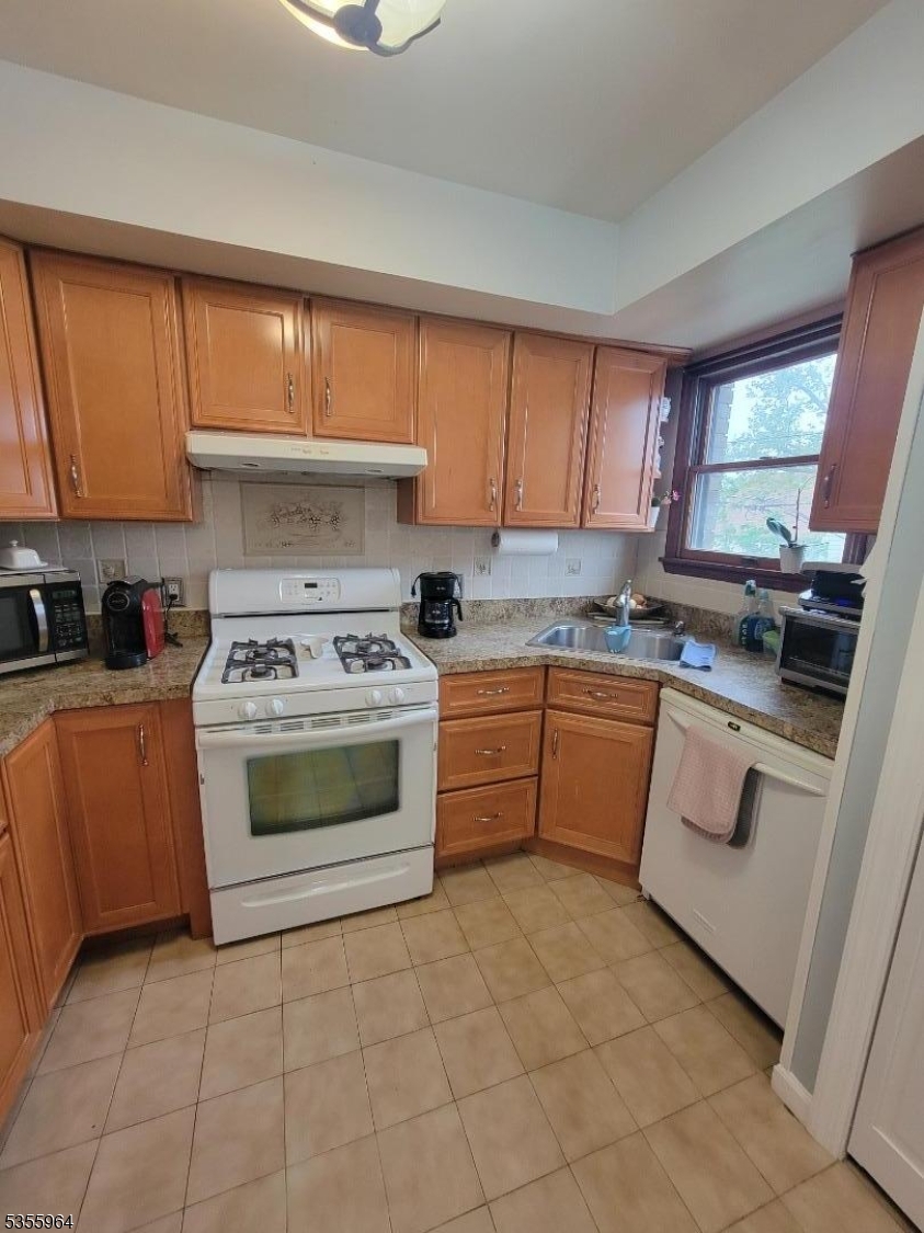 63 Rome Street Newark, NJ 07105 - Photo 5 of 11 a kitchen with a stove sink and cabinets