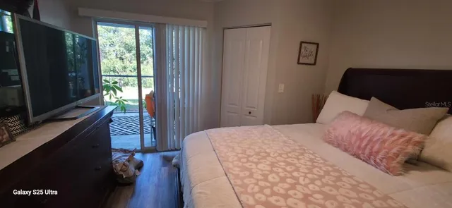 a bedroom with a bed window and a flat tv screen