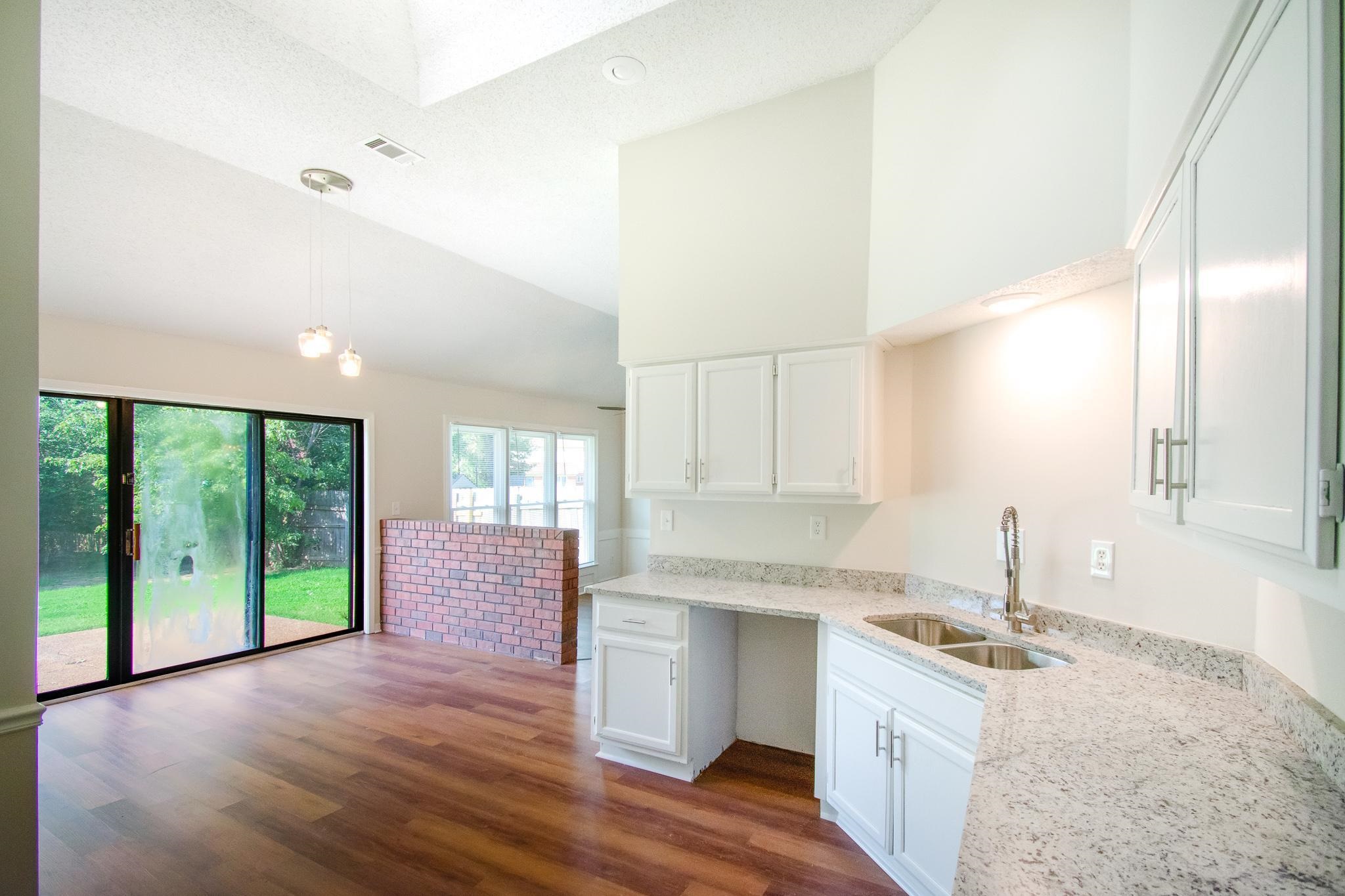 6756 Martha's Point Memphis, TN 38141 - Photo 4 of 15 a kitchen with granite countertop a stove a sink and a refrigerator