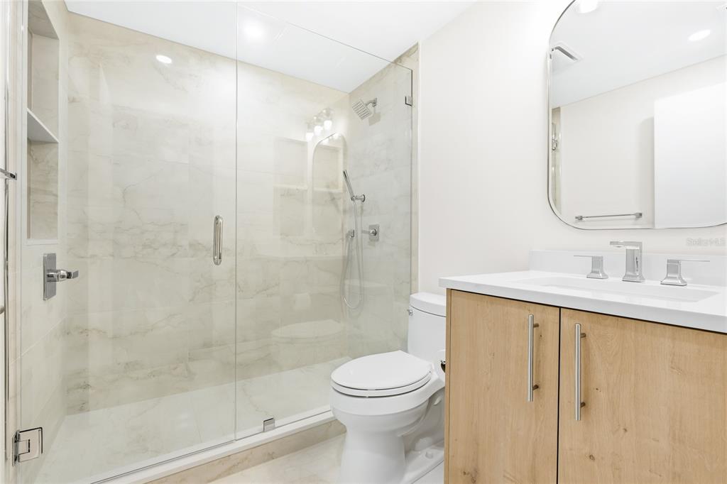 455 Longboat Club Road, Unit 408 Longboat Key, FL 34228 - Photo 21 of 58 a bathroom with a shower sink vanity mirror and toilet