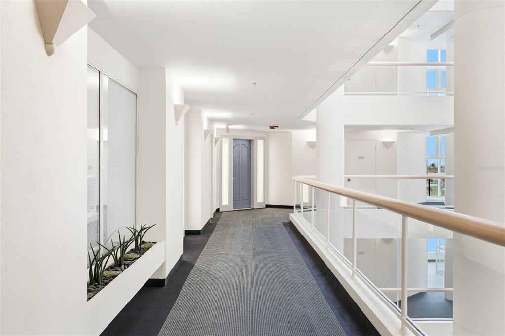 455 Longboat Club Road, Unit 408 Longboat Key, FL 34228 - Photo 32 of 58 a view of a hallway with white walls and wooden floor