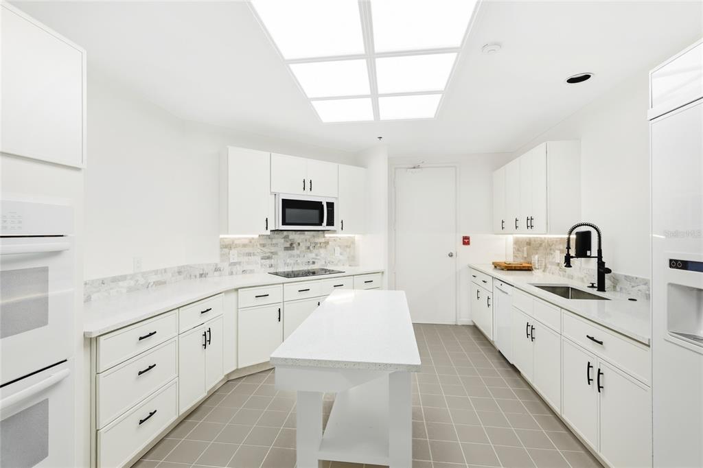 455 Longboat Club Road, Unit 408 Longboat Key, FL 34228 - Photo 50 of 58 a kitchen with granite countertop white cabinets and white appliances