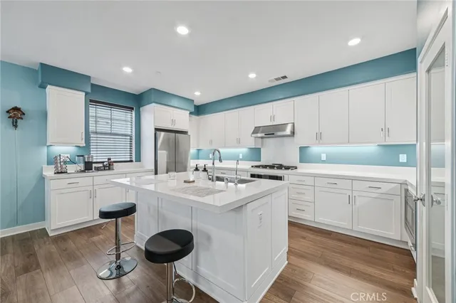 a kitchen with white cabinets and stainless steel appliances