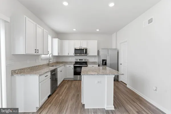 a kitchen with stainless steel appliances granite countertop a sink stove and cabinets