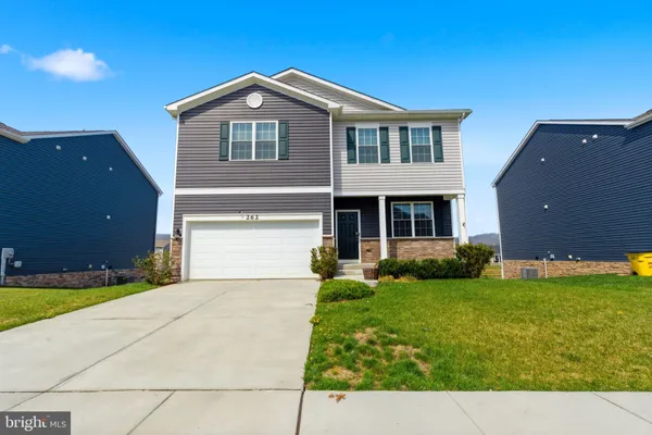 a view of a hallway with wooden floor and furniture