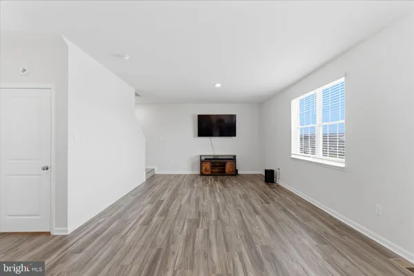 a view of a kitchen with wooden floor and windows