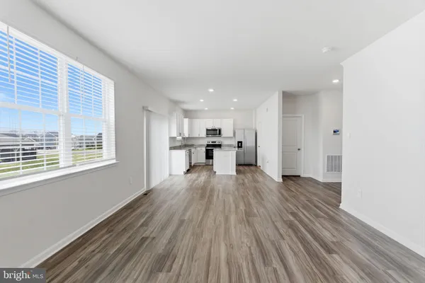 a view of a kitchen with stainless steel appliances granite countertop a stove and a wooden floors