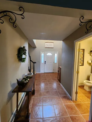 a view of a hallway to a livingroom with furniture and front door