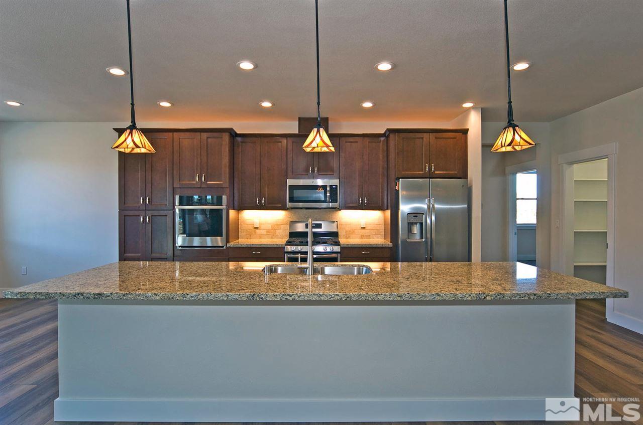 a kitchen with kitchen island a large counter top and stainless steel appliances