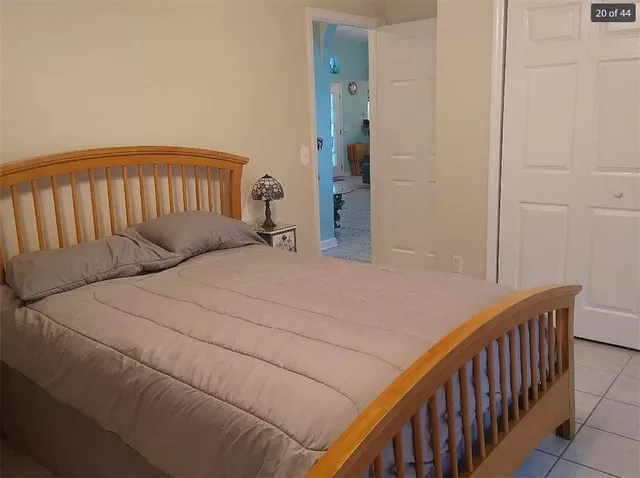 a bedroom with a bed and a wooden floor