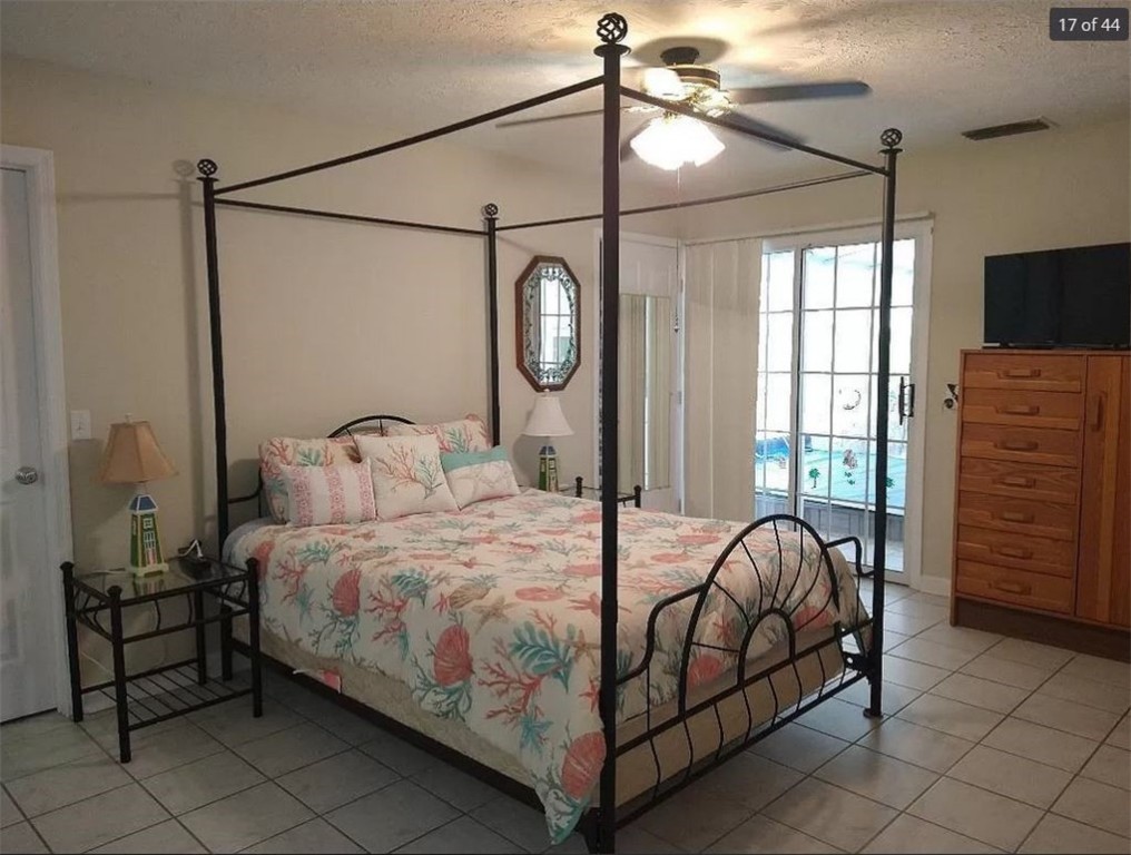 401 Coply Terrace Sebastian, FL 32958 - Photo 15 of 36 a bedroom with a bed and a chandelier