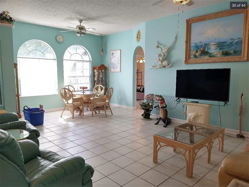 401 Coply Terrace Sebastian, FL 32958 - Photo 8 of 36 a living room with furniture a flat screen tv and a floor to ceiling window