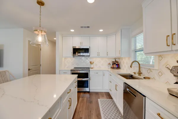 a kitchen with a sink a stove a refrigerator and cabinets