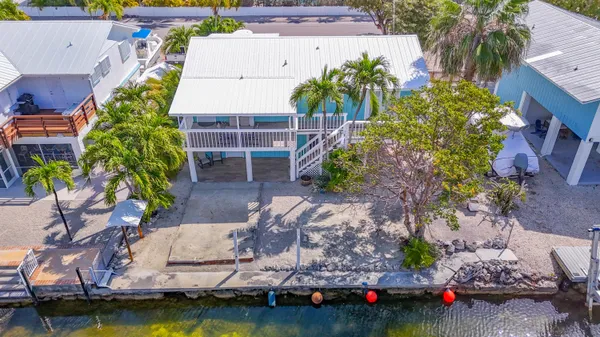 an aerial view of a house with a yard and a large pool