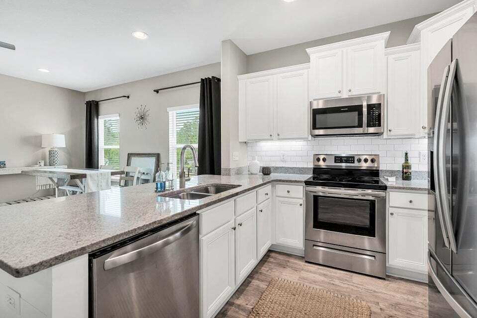 89 Crossing Lane, Unit F Santa Rosa Beach, FL 32459 - Photo 5 of 30 a kitchen with stainless steel appliances a sink a stove a microwave and a refrigerator