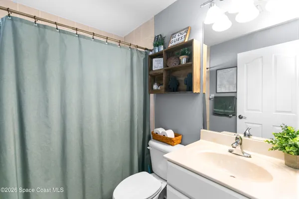a bathroom with a sink vanity mirror and toilet