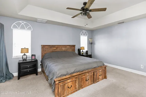 a spacious bedroom with a bed and a chandelier